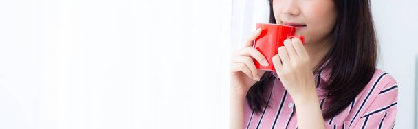 Nahaufnahme junge asiatische Frau mit trinken eine Tasse Kaffee stehend cu - Foto, Bild