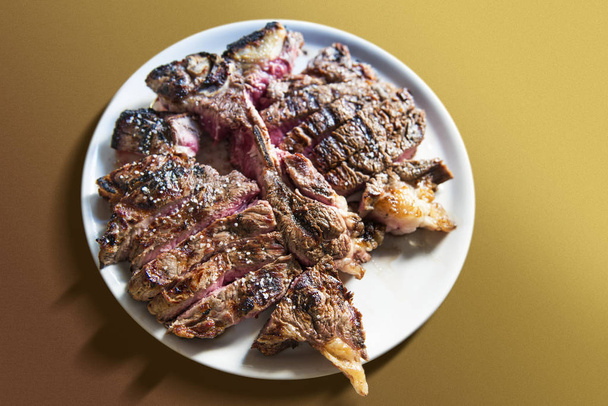 White round plate with cut grilled T-bone steak - Photo, Image