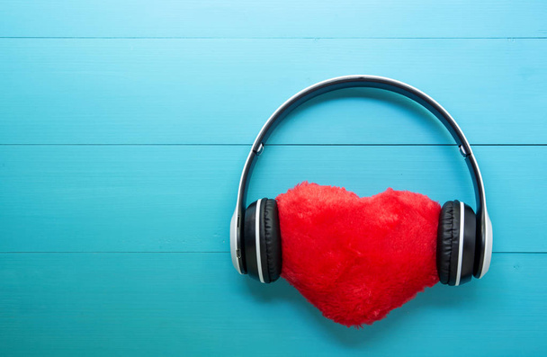 Słuchawki i kształt serca słuchanie muzyki na niebieskim drewnianym ekspresyjne - Zdjęcie, obraz
