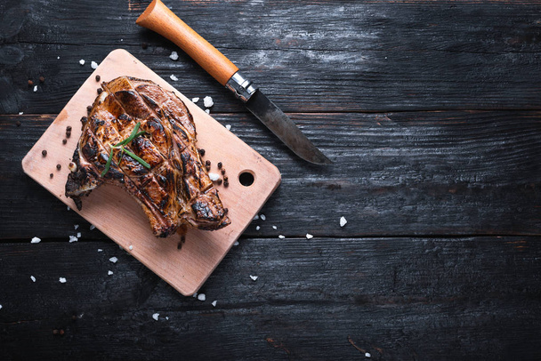 köstlich duftendes Steak liegt auf einem Schneidebrett, ein scharfes Messer für eine Wanderung, Gewürze und Salz. - Foto, Bild