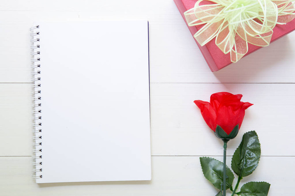 Huidige geschenk met rode roos bloem en notebook met kopie ruimte o - Foto, afbeelding