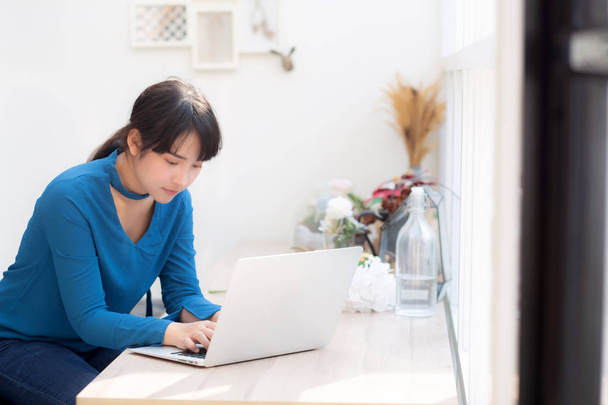 Beautiful portrait asia young woman working online on laptop sit - Фото, зображення