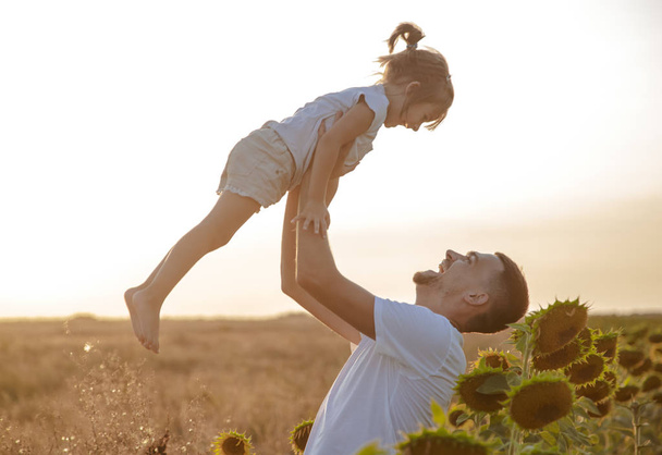 Счастливая семья, отец и дочь играют на поле
 - Фото, изображение