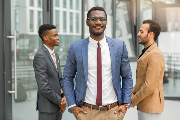 three handsome young men in suits near the building - Photo, image