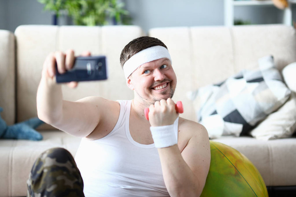 Sonriente deportista tomando fotos en el teléfono móvil
 - Foto, Imagen