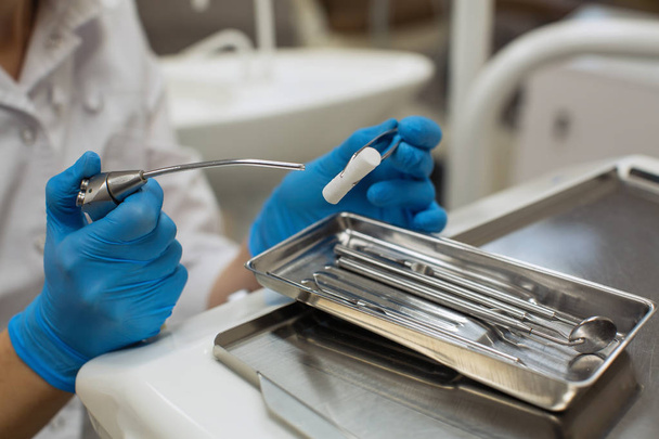 Tandarts handen houden detail van tandheelkundige instrumenten in tandheelkundige kliniek. - Foto, afbeelding