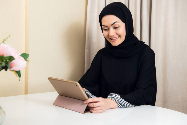 Грустная мусульманка, занятая бизнесом, держит планшет дома или в офисе
 - Фото, изображение