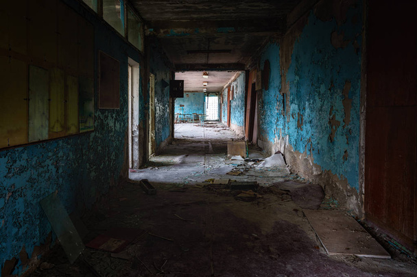Abandoned corridor in damaged building angle shot - Foto, imagen