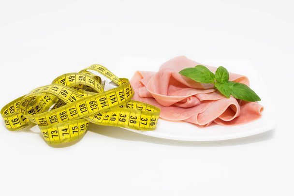 fatias de presunto cozido com fita métrica, conceito de dieta
 - Foto, Imagem