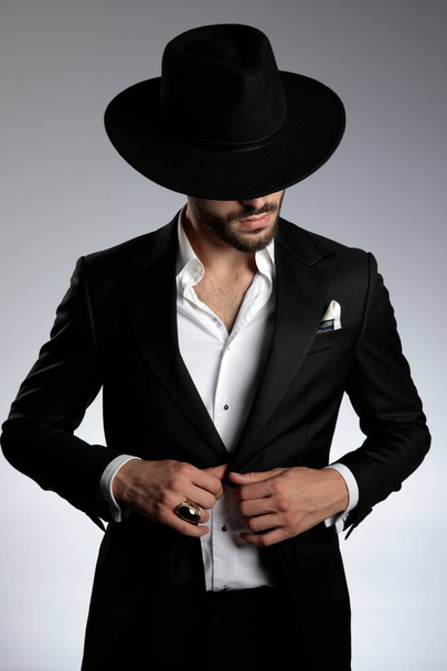 mysterious young model wearing tuxedo and black hat - Photo, Image