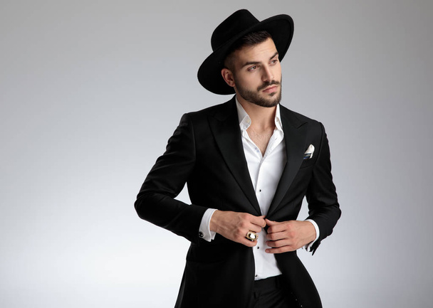 attractive young man wearing black tuxedo and hat - Fotografie, Obrázek