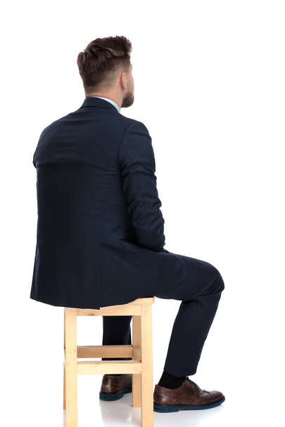 vissza véve a fiatal üzletember ül a fa szék - Fotó, kép