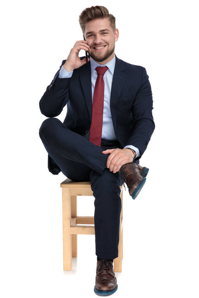 щасливий молодий бізнесмен розмовляє по телефону в студії
 - Фото, зображення