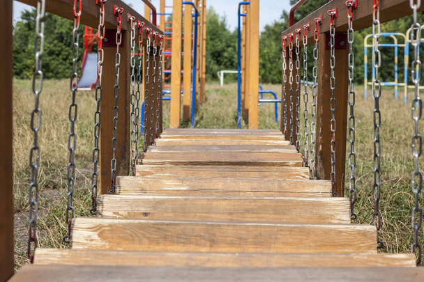 Playground for games with an obstacle course on a metal chain with wooden blocks - Photo, Image