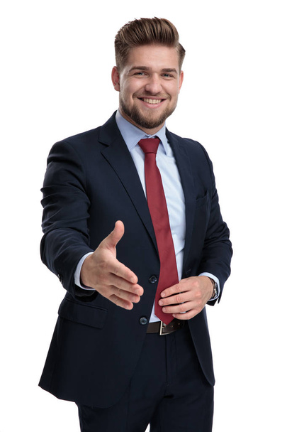 felice giovane uomo d'affari che tiene la cravatta e stringe la mano
 - Foto, immagini