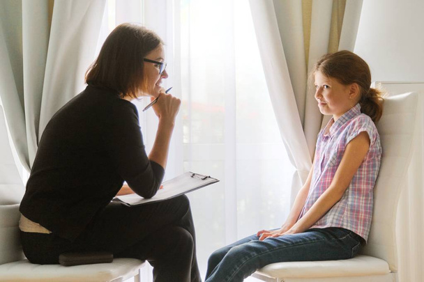 Girl talking to woman counselor psychologist discussing the feelings of child - Photo, image