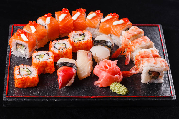 お昼の食事のおいしい日本食。魚介類。うなぎ、サーモン、鱒寿司、マグロ黒背景. - 写真・画像