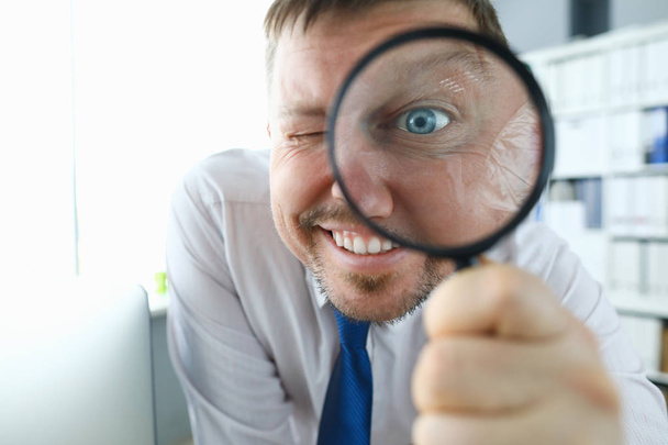 Smiling businessman hold magnifying glass - Photo, Image