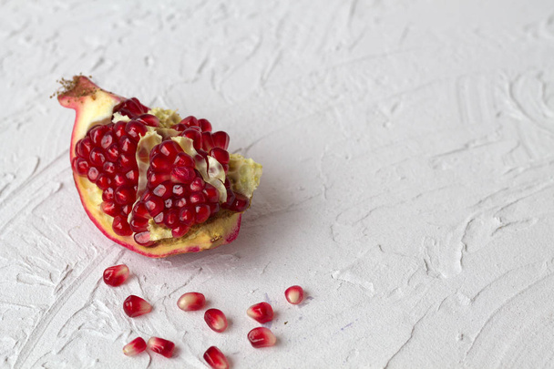 ripe pomegranate on a white background with copy space - Φωτογραφία, εικόνα