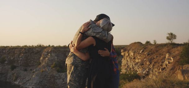 Soldaat knuffelen zijn vrouw en dochter - Foto, afbeelding