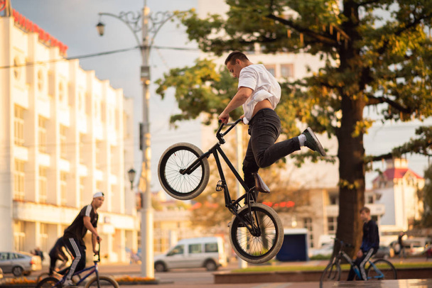 The guy performs a stunt on the BMX, jumping from the parapet high up. - Photo, Image