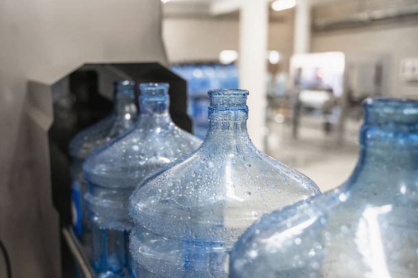 Saf su fabrikasında otomatik konveyör hattı veya bandı üzerinde mavi plastik şişeler - Fotoğraf, Görsel