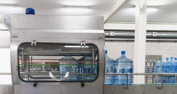Saf su fabrikasında otomatik konveyör hattı veya bandı üzerinde mavi plastik şişeler - Fotoğraf, Görsel