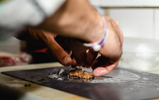 Het maken van Vietnamese traditionele loempia's door handen in een restaurant - Foto, afbeelding