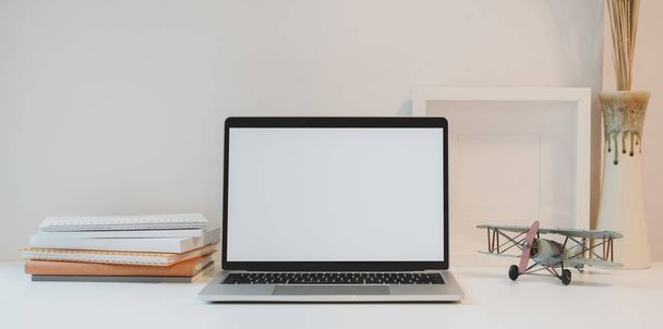 offener Blanko-Bildschirm-Laptop mit Kaffeetasse und Bürobedarf in einem minimalen Arbeitsplatz mit Kopierraum und Dekorationen - Foto, Bild