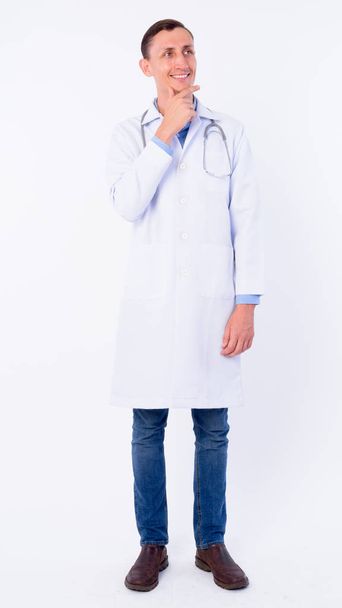 Full body shot of happy man doctor thinking and looking up - Photo, Image