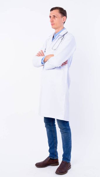 Full body shot of man doctor thinking and looking away - Photo, Image