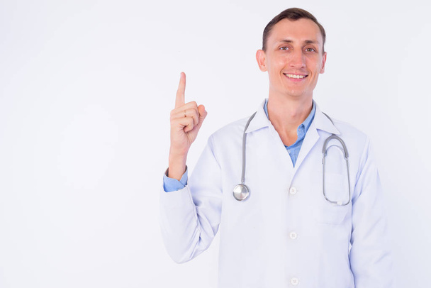 Студійний знімок щасливого лікаря, який вказує пальцем вгору
 - Фото, зображення
