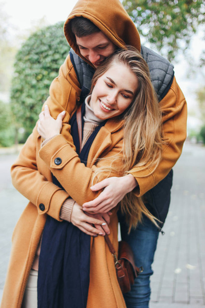 Счастливая молодая пара влюбленных подростков друзья одеты в непринужденный стиль на осенней улице города
 - Фото, изображение
