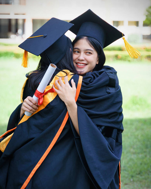 Genç Asyalı kadın üniversite mezunları, mezuniyet töreninde üniversite diploması aldıktan sonra arkadaşlarıyla keyifli ve mutlu bir kutlama yapıyor. Tebrikler, mezuniyet töreni.. - Fotoğraf, Görsel