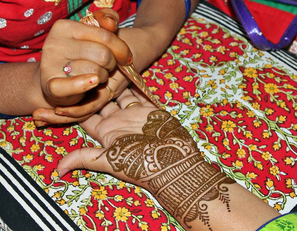 Красивая хна или мехенди украшение на руке индуистской невесты художником хной, на фоне подушек
 - Фото, изображение
