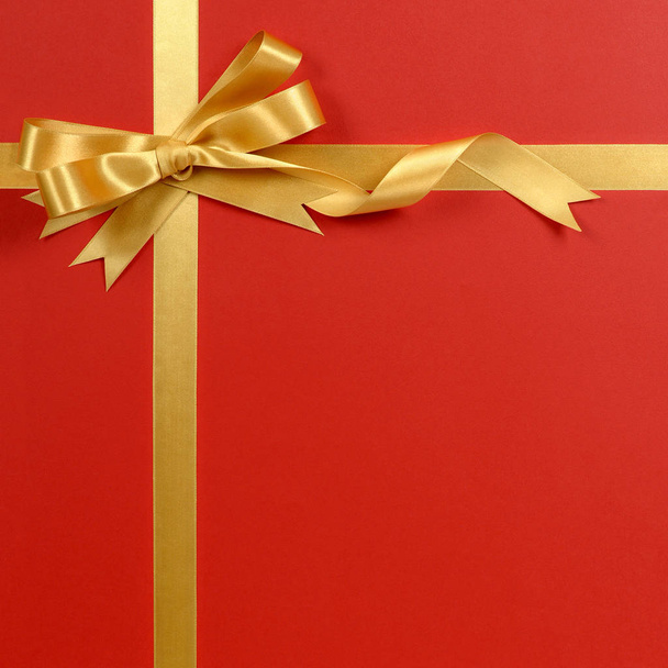 Karácsonyi ajándék határon arany szalag íj piros háttér függőleges - Fotó, kép