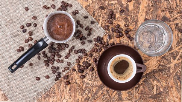 Kávé réz, csésze és víz. Görög kávé vízzel és kávéskanna. Török kávé és bab. - Fotó, kép