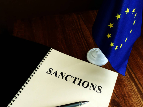 Sanctions list and EU flag on the desk. - Foto, immagini