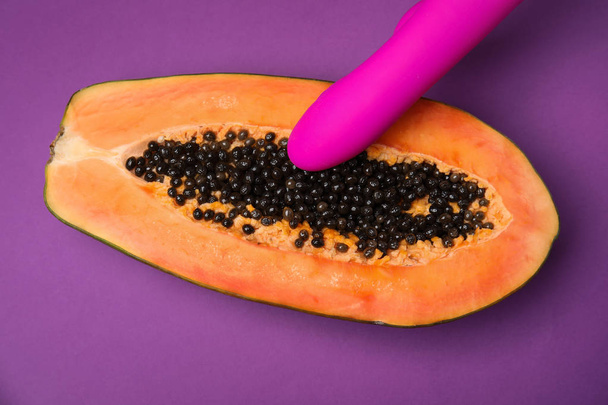 Half of papaya and vibrator on purple background, top view. Sex concept - Foto, Imagem