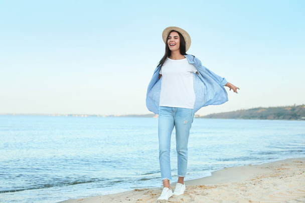 Beautiful young woman in casual outfit on beach - Fotoğraf, Görsel