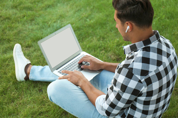 Portrait of young man with laptop outdoors. Space for design - Φωτογραφία, εικόνα