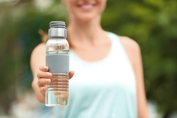 Young woman with bottle of water outdoors, closeup. Refreshing drink - Φωτογραφία, εικόνα