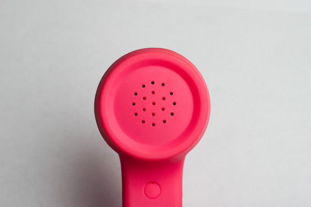 rosafarbener Telefonlautsprecher vor weißem Hintergrund - Foto, Bild