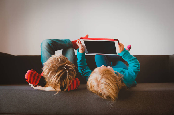 malý chlapec a dívka při pohledu na touch pad doma - Fotografie, Obrázek
