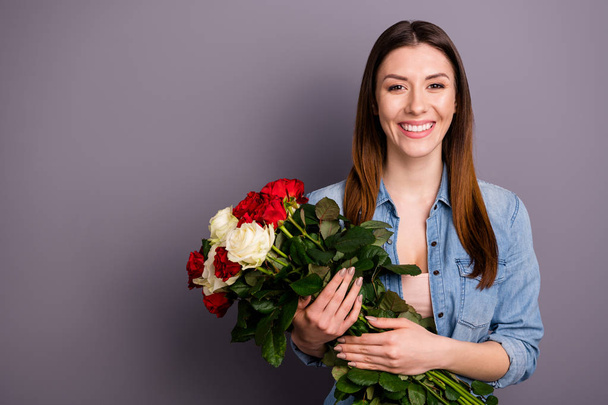 Portrait of positive cheerful woman hold hand bouquets of flowers roses get gift wear denim jeans clothes isolated over grey color background - Φωτογραφία, εικόνα