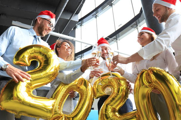 Business people are celebrating holiday in modern office drinking champagne and having fun in coworking. Merry Christmas and Happy New Year 2020. - Zdjęcie, obraz