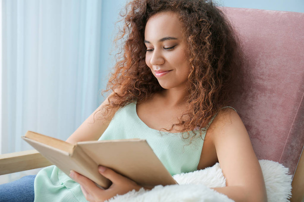 Mooie jonge vrouw die thuis boek leest - Foto, afbeelding