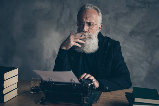 Close-up portrait of his he nice attractive bearded focused concentrated gray-haired professional skilled top creative publisher typing news life story article essay diary on concrete wall background - Photo, Image