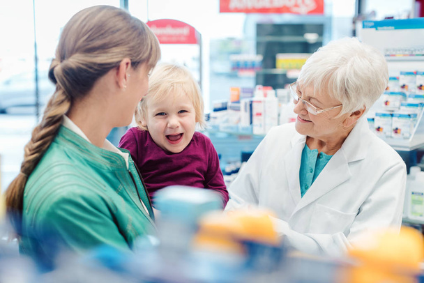 Amistoso farmacéutico, madre e hijo divirtiéndose en farmacia
 - Foto, imagen