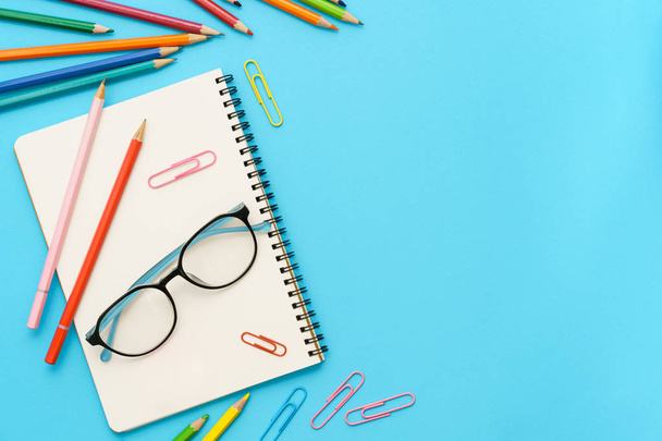 Flat lay photo of office desk with colorful pencil, Paper clip,  Note book, Glasses, Top view of the copy space - Foto, Imagem